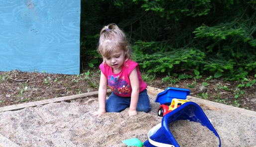 Sophie speelt leuk mee in de zandbak.